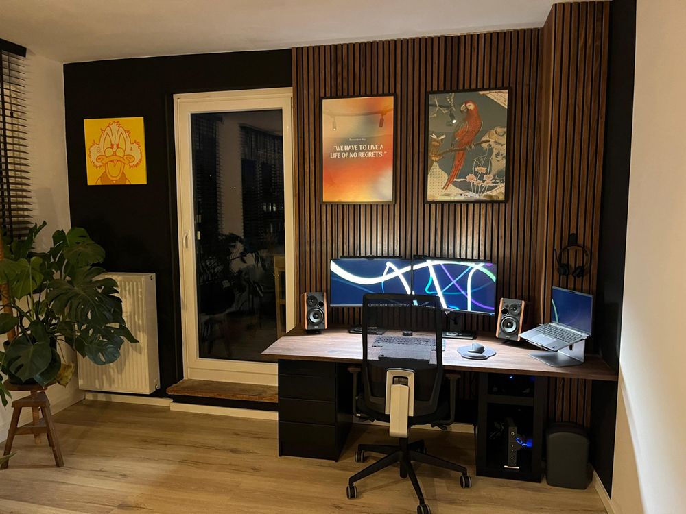 Arbeitszimmer mit montierten Akustikpaneelen und Schreibtisch mit massiver Arbeitsplatte.