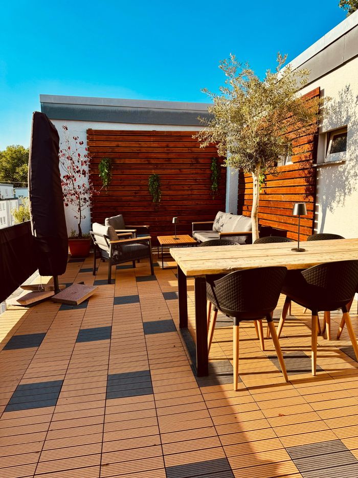 Verlegte WPC-Fliesen auf einer Dachterrasse sowie mit Akustik-Dielen verkleidete Wände.